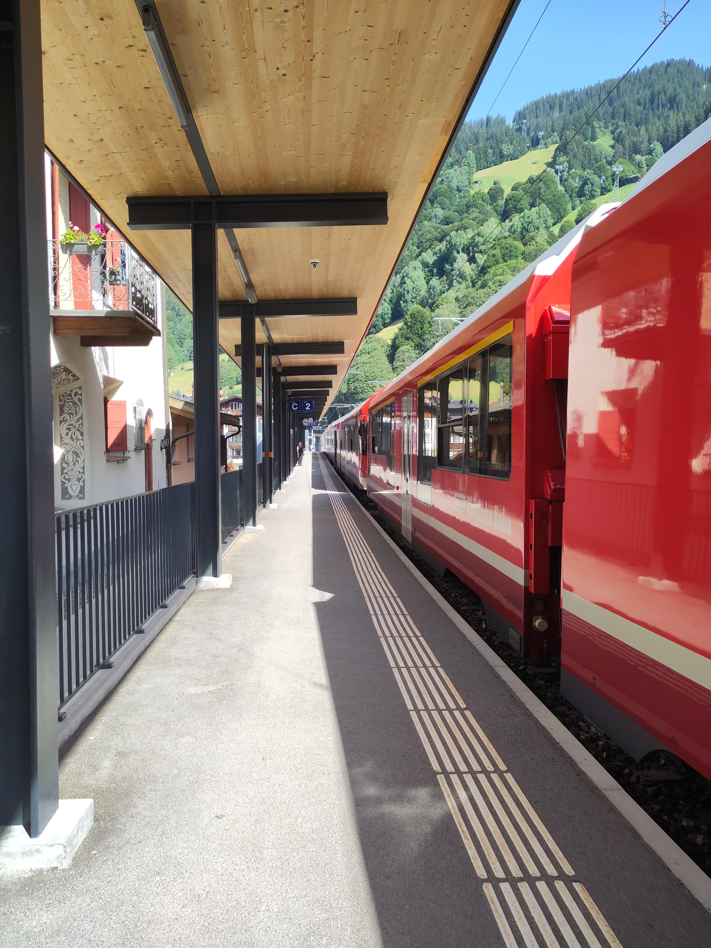 Foto. Ein roter Zug im Bahnhof.