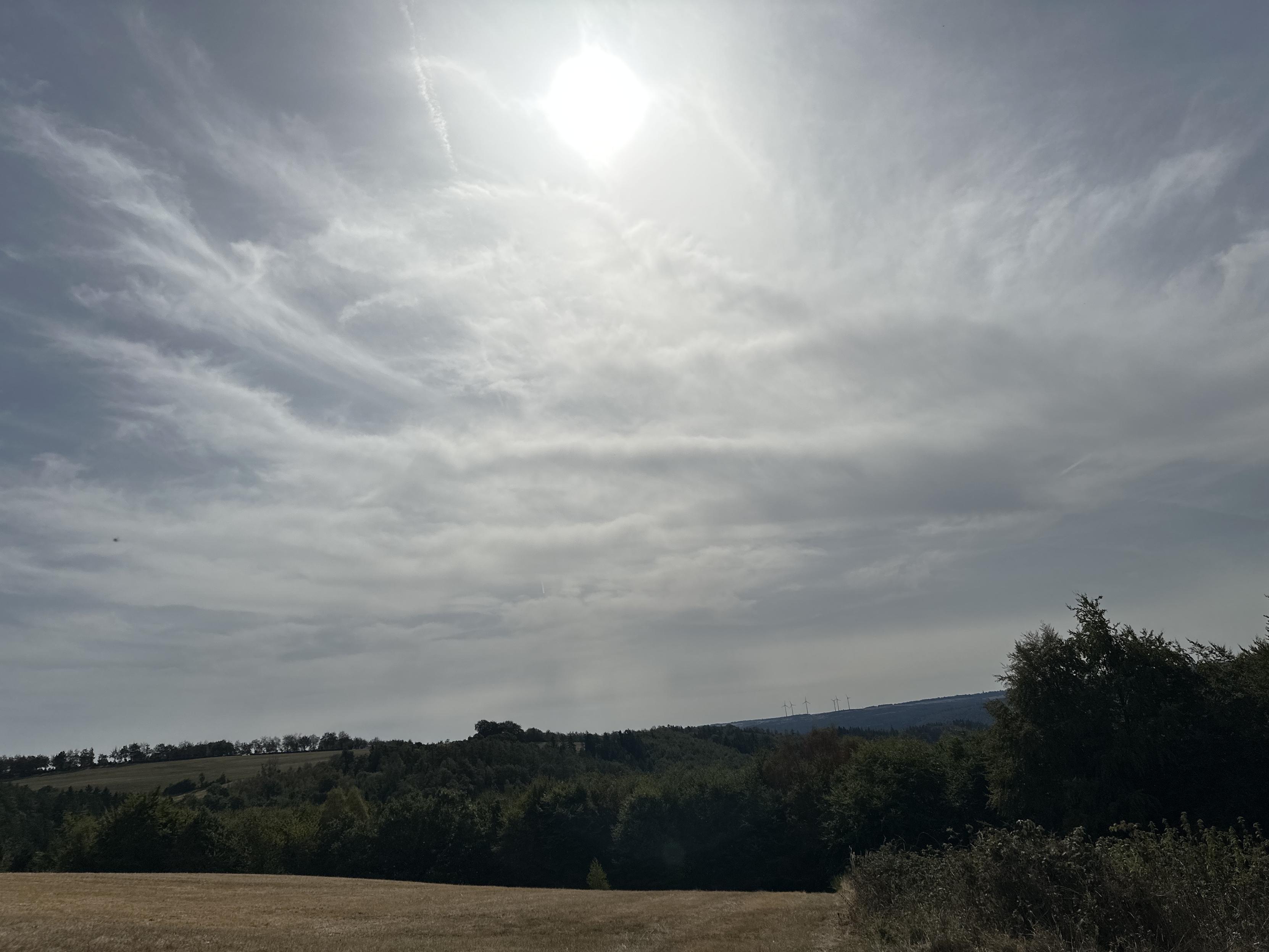 Weite Landschaft und die Sonne verdeckt mit Wolken.